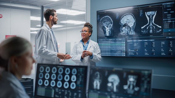 Doctors looking at MRI scans to evaluate a glioblastoma.