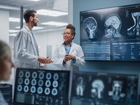 Doctors looking at MRI scans to evaluate a glioblastoma.