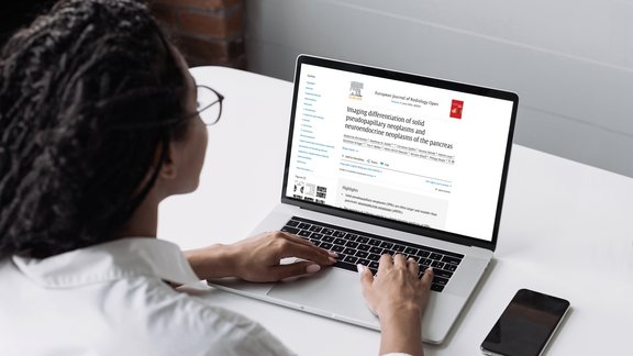 Medizinerin liest Pankreas-Studie auf Laptop