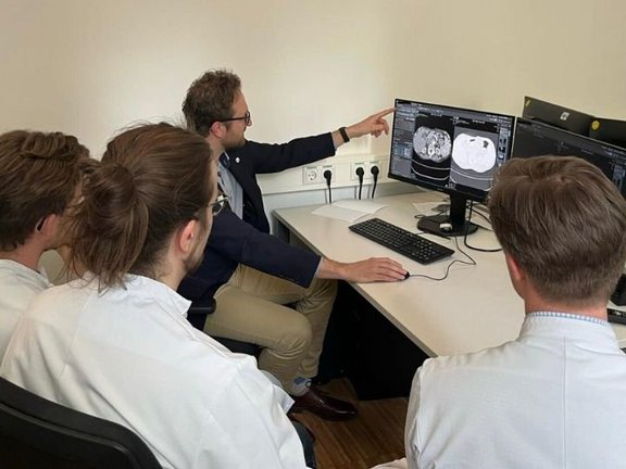 Ärzte vor einem Computer; Bild in der medizinischen Bildgebungssoftware mint Lesion