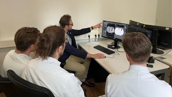 Ärzte vor einem Computer; Bild in der medizinischen Bildgebungssoftware mint Lesion