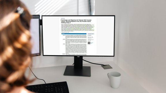 Eine Radiologin liest die aktualisierten PCWG4-Richtlinien für klinische Studien zum Prostatakarzinom