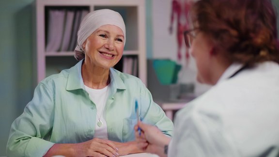 Eine Onkologin bespricht einen Krebsfall mit einer Patientin und erläutert die Informationen, die der von mint Lesion™ erstellte Befund enthält. 