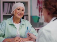 A picture of a cancer patient talking to the doctor who is treating her.